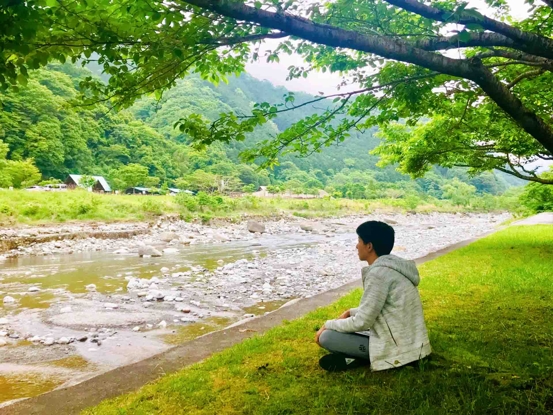 川辺で物思いにふける男性